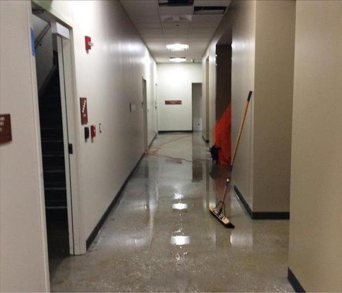 Commercial hallway with pools of water after a loss.